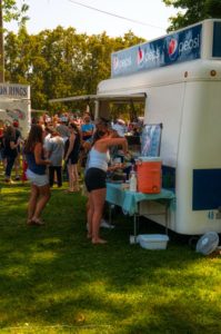A group of people enjoying a local food truck festival